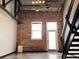 Spacious living room features exposed brick wall, hardwood floors, and industrial staircase at 1111 Osage St # 7, Denver, CO 80204