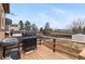 Outdoor back deck featuring a grill, wood railing, and a view of the backyard at 3977 S Pitkin Way, Aurora, CO 80013