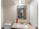 Bathroom with modern vanity, stone accent mirror, and view into living area beyond open door at 3977 S Pitkin Way, Aurora, CO 80013