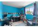 Bright bedroom with blue walls, a built-in bookshelf, and a comfortable armchair at 3977 S Pitkin Way, Aurora, CO 80013