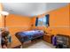 Cozy bedroom with bright orange walls, tiled floor and comfortable decor at 3977 S Pitkin Way, Aurora, CO 80013