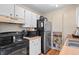Well-lit kitchen featuring stainless steel refrigerator, black range, wooden counters and plenty of storage at 3977 S Pitkin Way, Aurora, CO 80013