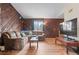 Cozy living room features wood paneling, hardwood floors, and a large comfortable sectional sofa at 3977 S Pitkin Way, Aurora, CO 80013