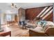Inviting living room with a stone fireplace, wood paneling, and hardwood floors, perfect for entertaining at 3977 S Pitkin Way, Aurora, CO 80013