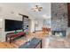 Spacious living room boasts hardwood floors, a stone fireplace, and vaulted ceilings with a ceiling fan at 3977 S Pitkin Way, Aurora, CO 80013