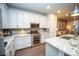 Gourmet kitchen with white cabinets, stainless steel appliances, a stone backsplash, and ample counter space at 359 Courtfield Way, Castle Pines, CO 80108