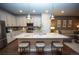 Bright kitchen featuring white cabinetry, a large island with seating, and stainless steel appliances at 359 Courtfield Way, Castle Pines, CO 80108