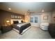 Spacious main bedroom features neutral walls, plush carpet, modern ceiling fan, and a chair near the window at 359 Courtfield Way, Castle Pines, CO 80108