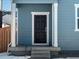 Dark brown front door with white trim, on a light gray house with a covered porch at 229 Mayfly Ln, Berthoud, CO 80513