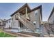 Exterior of house featuring a backyard patio, stairs to a balcony, and landscaping for a comfortable outdoor space at 21436 E Stanford Ave, Aurora, CO 80015