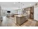 Open-concept kitchen with stainless steel appliances, island seating, and a seamless flow to the living area at 21436 E Stanford Ave, Aurora, CO 80015
