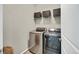 Efficient laundry room with modern washer and dryer, complemented by practical shelving for storage at 21436 E Stanford Ave, Aurora, CO 80015