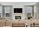 Inviting living room with a cozy fireplace, large windows, and comfortable seating for relaxation and entertainment at 21436 E Stanford Ave, Aurora, CO 80015