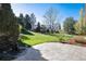 A beautifully landscaped backyard featuring a stone patio, water feature, and lush lawn at 8004 S Oneida Ct, Centennial, CO 80112