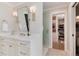 Bright bathroom features a white vanity with double sconces and large mirror, and a walk-in closet at 8004 S Oneida Ct, Centennial, CO 80112