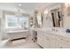 Bright bathroom featuring a soaking tub, dual sinks, and white cabinetry at 8004 S Oneida Ct, Centennial, CO 80112