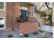 Charming brick front entrance with black door, minimalist railing, and beautiful landscaping detail at 8004 S Oneida Ct, Centennial, CO 80112