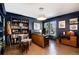 Stylish home office featuring dark blue walls, built-in bookshelves, and natural light from the windows at 8004 S Oneida Ct, Centennial, CO 80112