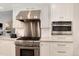 Modern kitchen with stainless steel appliances, white cabinets, and a stylish range hood at 8004 S Oneida Ct, Centennial, CO 80112