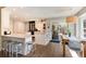 Spacious, bright kitchen featuring hardwood floors, bar seating, white cabinets, and stainless steel appliances at 8004 S Oneida Ct, Centennial, CO 80112