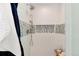 Newly renovated shower boasts white subway tile with blue accent and a shower niche with decor at 8004 S Oneida Ct, Centennial, CO 80112