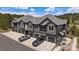 An aerial view of gray townhomes with garages and parking spaces, landscaped lawns, and a private balcony at 31191 Black Eagle Dr # 304, Evergreen, CO 80439