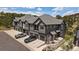 Stunning view of the townhouse exterior with gray siding, private garages, and landscaped surroundings at 31191 Black Eagle Dr # 304, Evergreen, CO 80439
