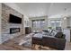 Modern living room features a stone fireplace, hardwood floors, and a comfortable sectional at 31191 Black Eagle Dr # 304, Evergreen, CO 80439