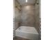 Modern shower-tub combination with gray tiled walls and updated fixtures and unique decorative tile at 31191 Black Eagle Dr # 304, Evergreen, CO 80439