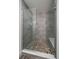 Modern shower with glass enclosure, stone tile flooring and tiled walls at 31191 Black Eagle Dr # 304, Evergreen, CO 80439