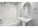 Clean white bathroom with tub, shower, pedestal sink, and oval mirror at 22090 E Arbor Dr, Aurora, CO 80016