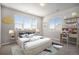 Serene bedroom featuring a study area, large windows, cloud decor and a comfortable bed with patterned pillows at 22090 E Arbor Dr, Aurora, CO 80016