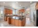 Well-lit kitchen with center island, stainless steel appliances, granite countertops, and custom wood cabinets at 22090 E Arbor Dr, Aurora, CO 80016