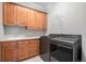 Laundry room features wooden cabinets, a sink, and stainless steel washer and dryer at 22090 E Arbor Dr, Aurora, CO 80016