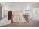 Carpeted loft with wrought iron railing, natural light, and vaulted ceilings at 22090 E Arbor Dr, Aurora, CO 80016