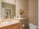 Well-appointed half bathroom featuring stylish wallpaper, a vanity sink, and a decorative mirror at 16631 Red Cliff Cir, Morrison, CO 80465