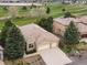 An aerial view of a well-maintained home near a golf course, boasting a spacious driveway and mature trees at 16631 Red Cliff Cir, Morrison, CO 80465