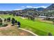 A scenic aerial view of the lush golf course, surrounded by trees and houses, offers a glimpse of a relaxing community at 16631 Red Cliff Cir, Morrison, CO 80465