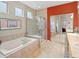 Bright bathroom featuring a soaking tub, glass-enclosed shower, and vanity, with view into the main bedroom at 16631 Red Cliff Cir, Morrison, CO 80465