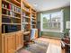 Inviting office with built-in bookshelves, hardwood floors, and a large window at 16631 Red Cliff Cir, Morrison, CO 80465