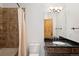 The bathroom features a shower over tub, a granite counter, and a decorative mirror at 11227 Explorers Run, Littleton, CO 80125