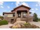 Charming exterior showcasing a covered porch, stone accents, manicured landscaping, and a welcoming entrance at 11227 Explorers Run, Littleton, CO 80125