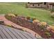 Landscaping featuring a stone walkway with decorative plants, mulch, and a green lawn at 11227 Explorers Run, Littleton, CO 80125