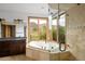 Bright main bathroom with a soaking tub, glass enclosed shower, granite countertop and natural views at 11227 Explorers Run, Littleton, CO 80125
