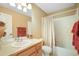 Bright bathroom showcasing a bathtub with a curtain, a sink with vanity, and neutral walls at 21863 E Oxford Pl, Aurora, CO 80018