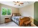 Well-lit bedroom with a plaid-covered bed, side table, ceiling fan, and bright window at 21863 E Oxford Pl, Aurora, CO 80018