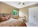 Cozy bedroom showcasing a patterned bedspread, ceiling fan, and a light-filled window at 21863 E Oxford Pl, Aurora, CO 80018