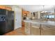 Open kitchen with light wood cabinets, an island, and stainless-steel appliances with hardwood floors at 21863 E Oxford Pl, Aurora, CO 80018