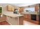 Traditional kitchen features light wood cabinets, black appliances, and a breakfast bar with tile countertop at 21863 E Oxford Pl, Aurora, CO 80018