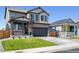 Two-story house with gray siding, stone accents, and a two-car garage at 9876 Ceylon Ct, Commerce City, CO 80022